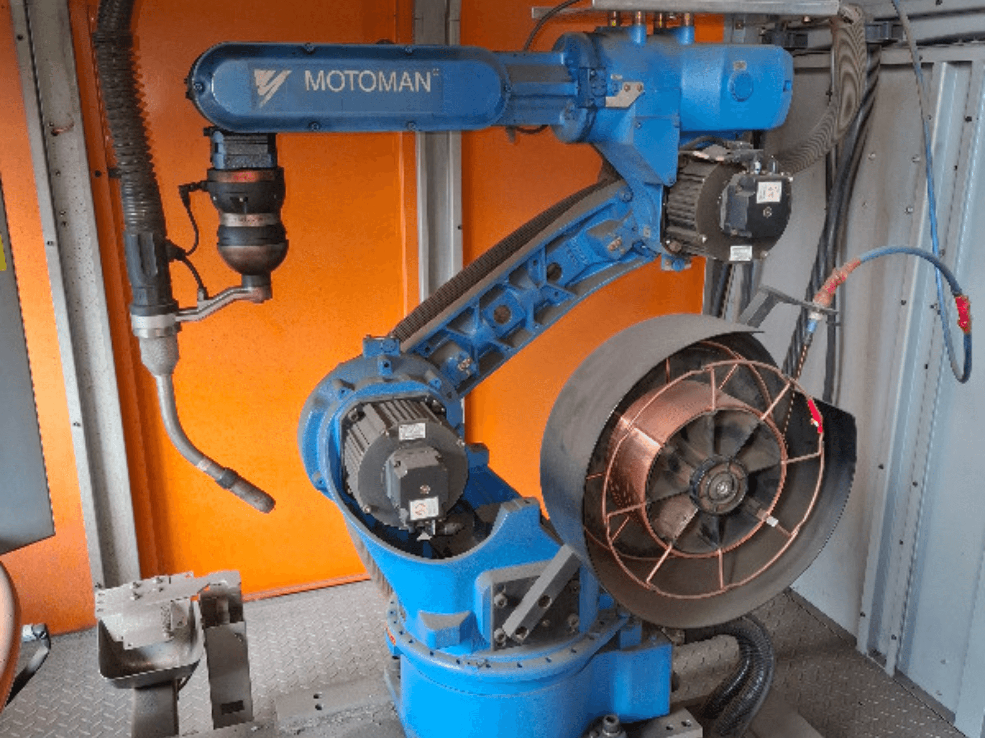 Bras robotique MOTOMAN en bleu, vue latérale, avec ventilateur et outillage attachés, montrant les détails mécaniques et les connexions.