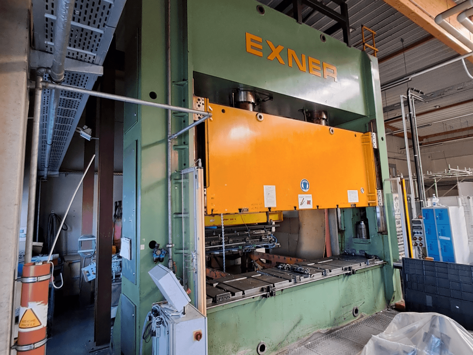 Presse hydraulique EXNER EX SBR 200 vue de profil, avec une plaque de pressage orange et un panneau de commande visible.