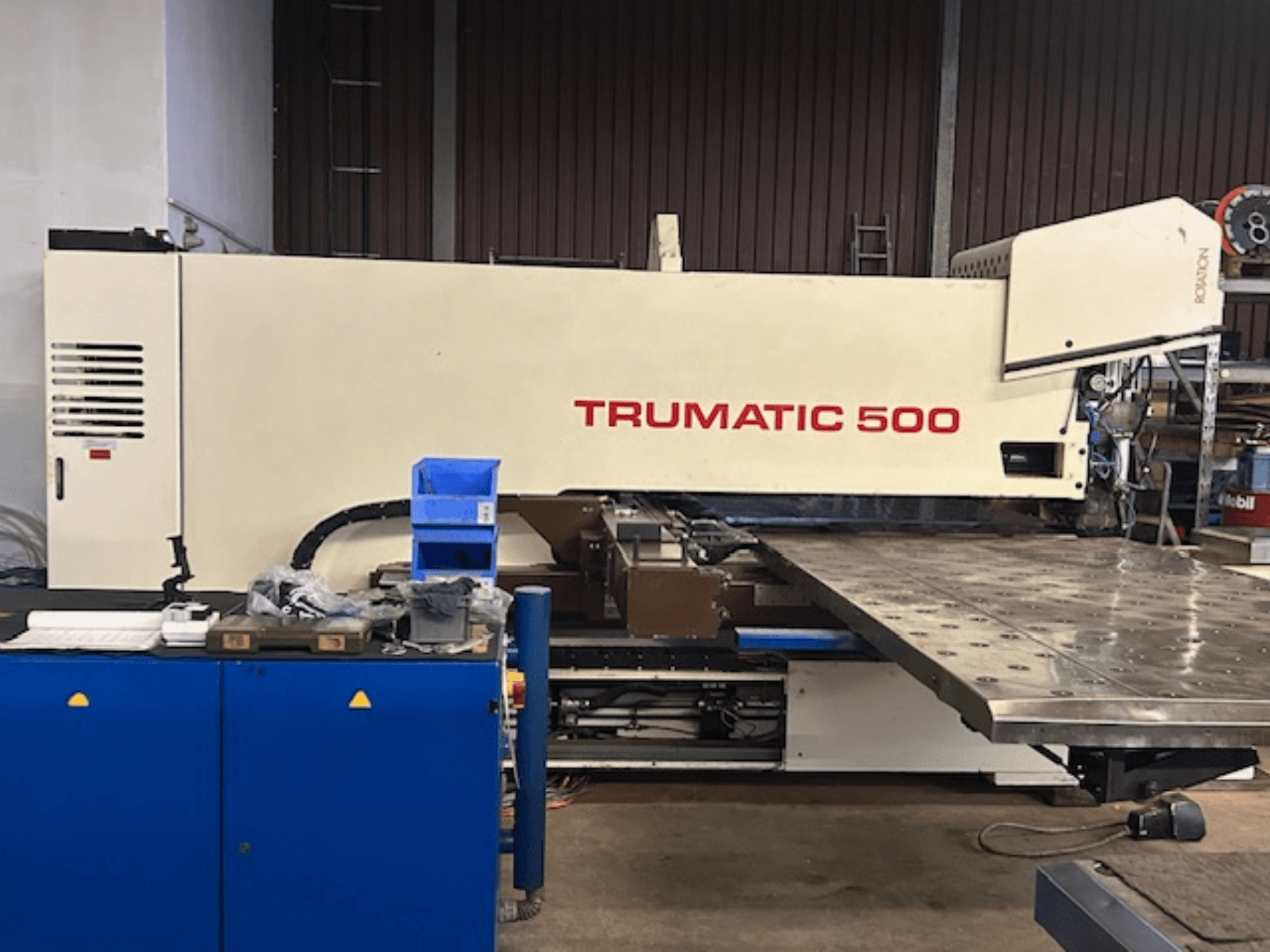 Poinçonneuse TRUMPF TRUMATIC 500 CNC, vue de face, avec panneau de commande et une grande table de travail présentant une surface perforée.