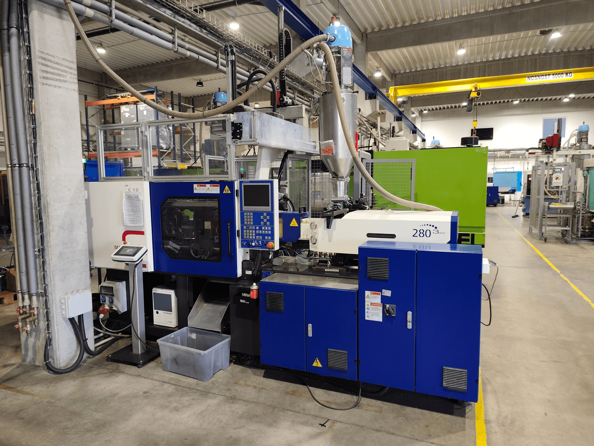 Presse à injection hydraulique HAITIAN Mars III MA 900/280 A ECO, vue de profil, montrant les commandes et l'unité d'alimentation.