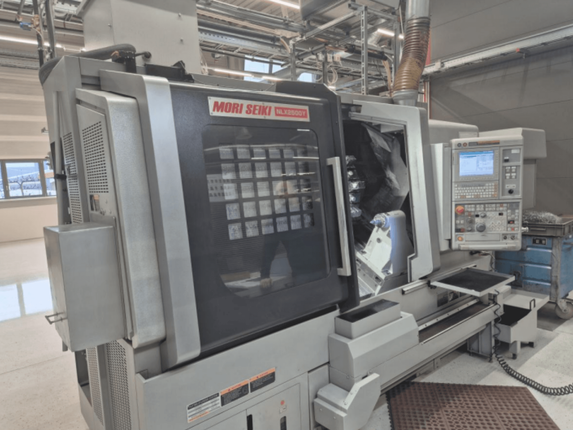 Tour CNC MORI SEIKI NL2500Y en usine, vue de face montrant le panneau de commande et la chambre de travail.