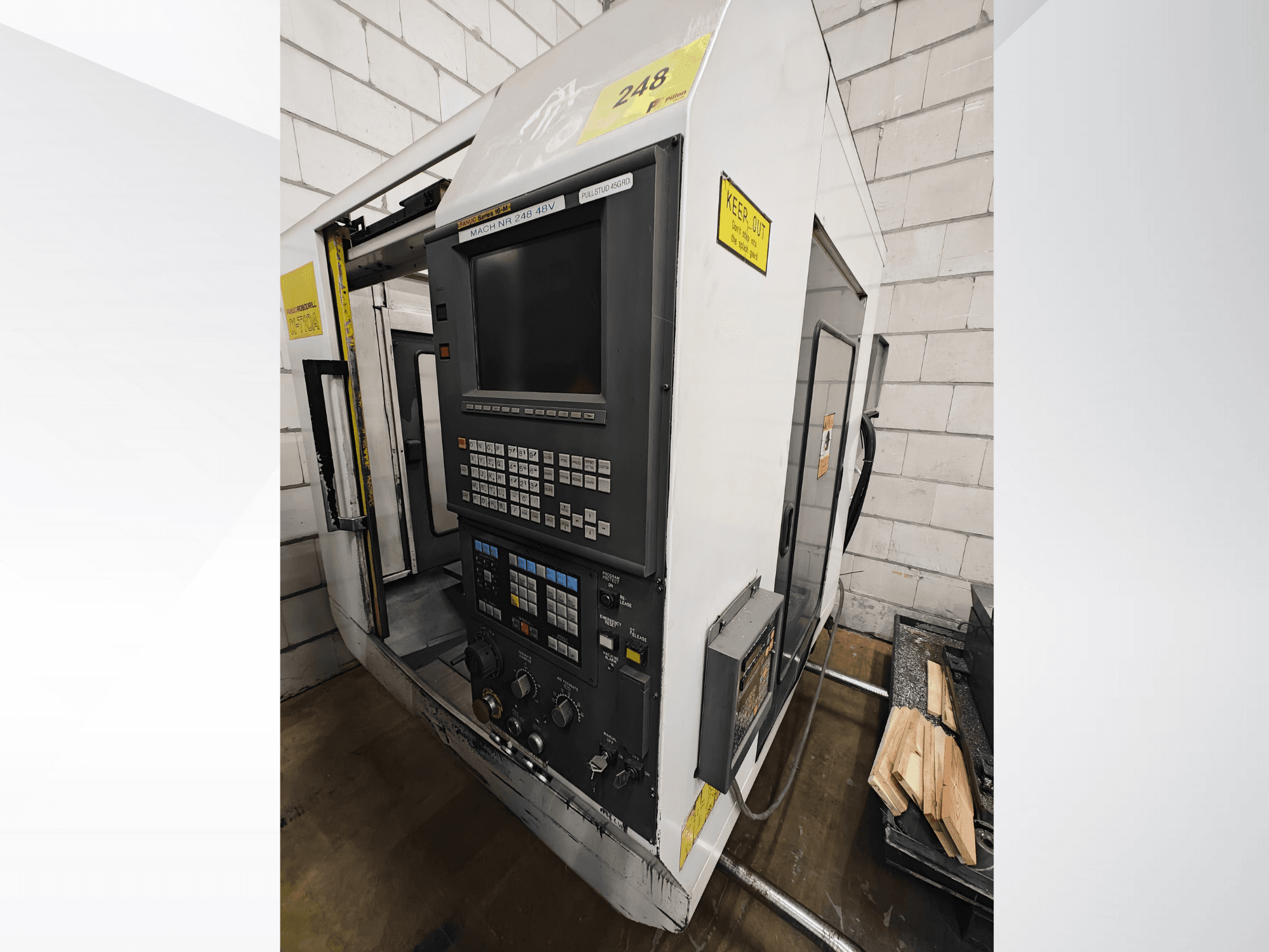 Machine CNC modèle Nr 248, vue de face, comportant un panneau de commande avec boutons et écran, avec des pièces de bois sur une étagère à proximité.